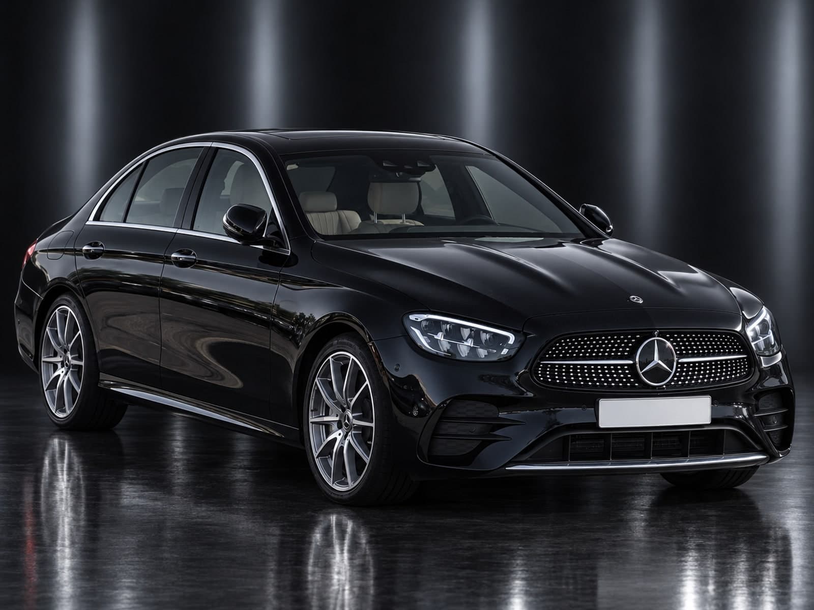 Black Mercedes E-Class Saloon in a dark studio, front three-quarter view